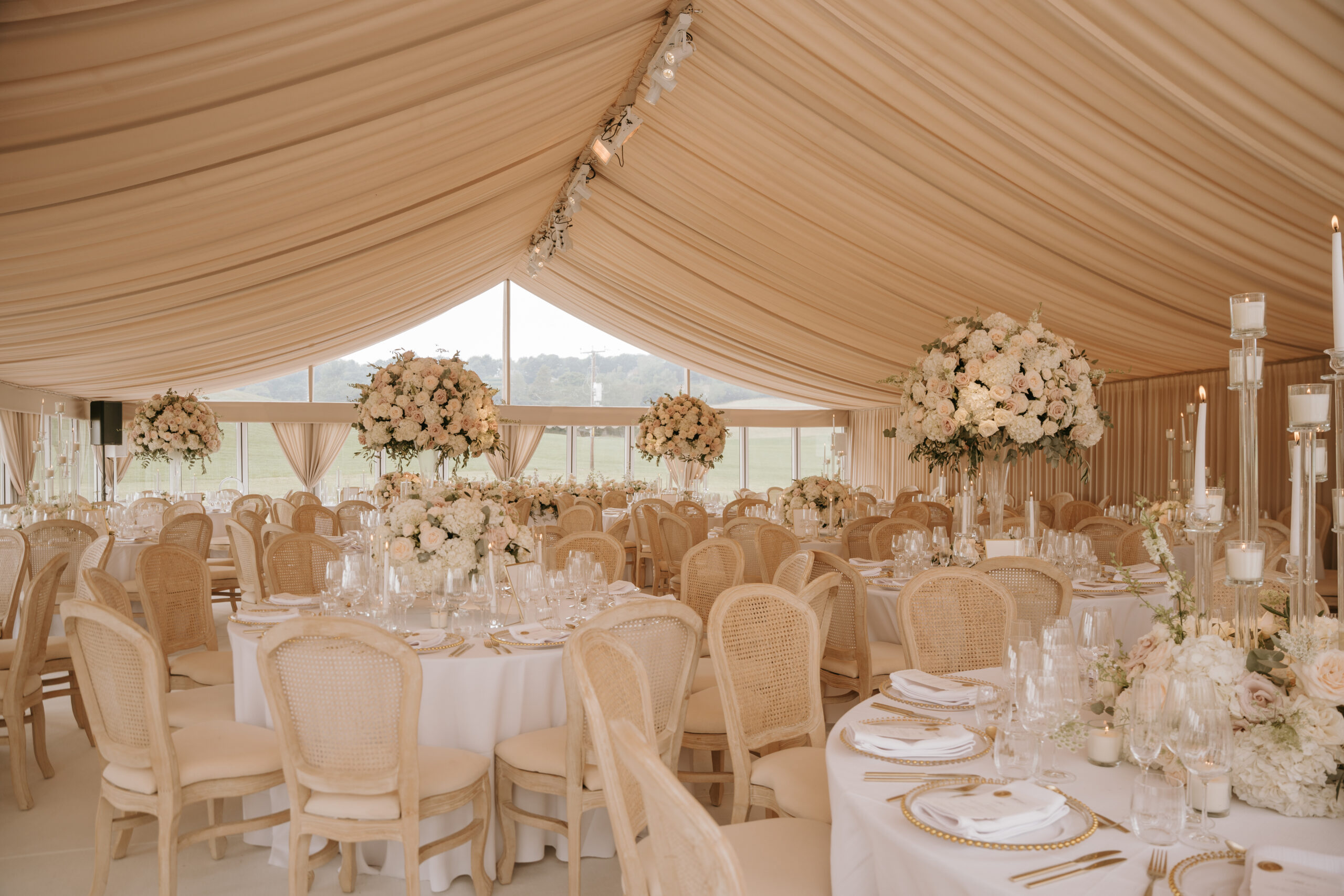 Elegant marquee wedding setup in Cheshire featuring romantic floral arrangements, soft lighting, and luxury table settings planned by Dale Alexander Events